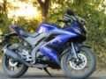 Purple Yamaha R15 V3 motorcycle parked outdoors on a sunny day, showcasing its sporty design.