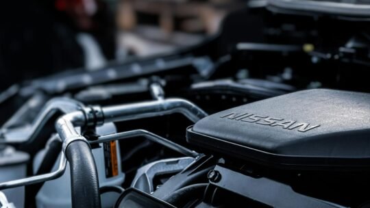 Detailed view of a car engine compartment with visible Nissan branding.