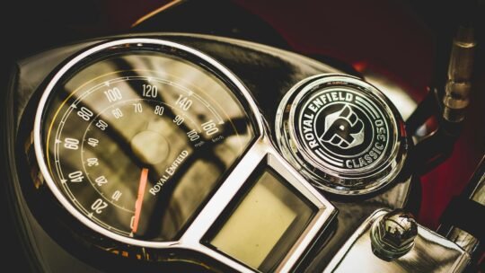 Detailed view of a Royal Enfield motorcycle speedometer with a classic emblem.