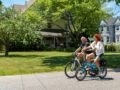 A couple riding electric bikes on a sunny day in Patchogue, NY, enjoying outdoor leisure.