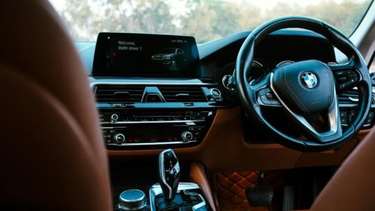 Close-up of a modern BMW vehicle's interior showcasing the dashboard, steering wheel, and digital screen.