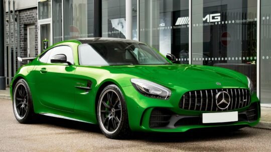 Vibrant green Mercedes-AMG GT R sports car parked outside a modern showroom.
