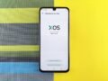 Smartphone on colorful background showing XOS version update, based on Android.