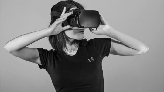 Black and white portrait of a young woman using a VR headset.