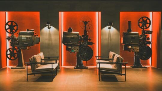 A cozy retro cinema room showcasing vintage film projectors and comfortable seating.
