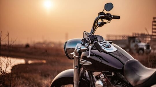Harley Davidson motorcycle parked outdoors at sunset, capturing the warm glow and serene environment.