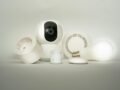 A collection of smart home devices, including a camera, light bulb, and sensors, on display.