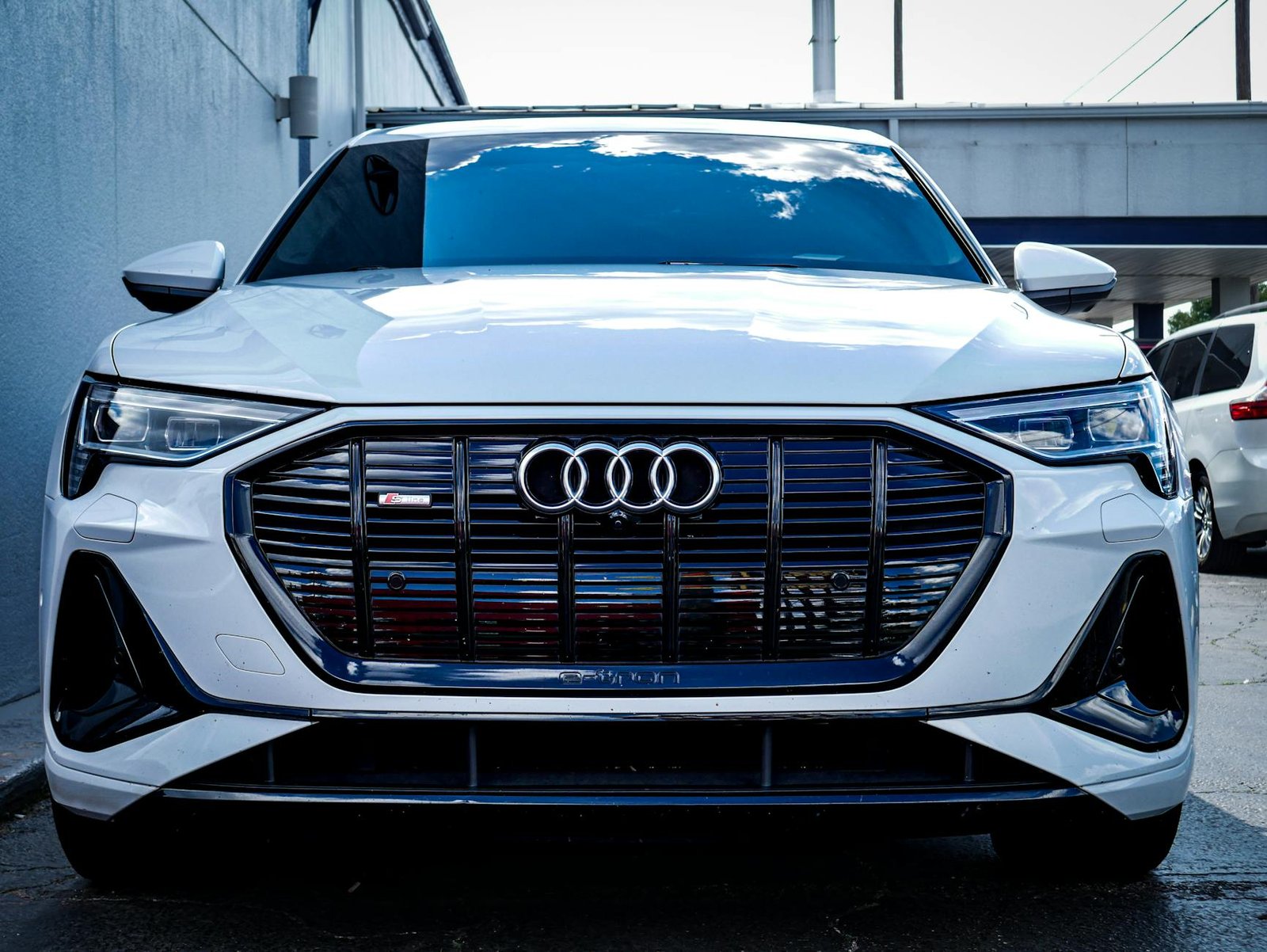 Sleek white Audi E-Tron SUV captured outdoors with a modern design.