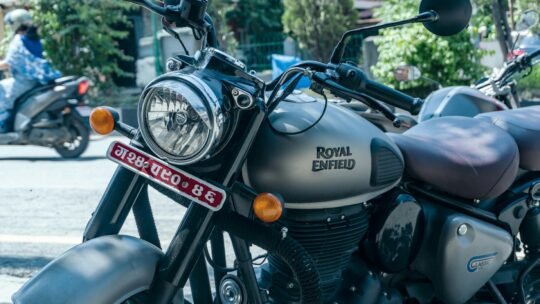 Detailed shot of a Royal Enfield motorcycle parked on a sunny street.