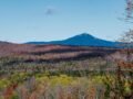 Breathtaking panoramic vista of the Adirondacks in fall, showcasing vibrant foliage and distant peaks.