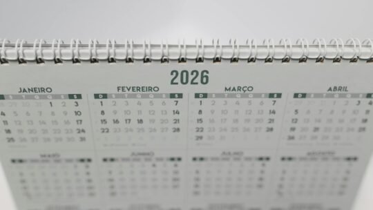 Close-up of a 2026 spiral-bound desk calendar with months in Portuguese.