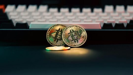 Golden Bitcoin coins in front of a keyboard, symbolizing digital currency and finance