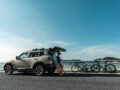 Modern SUV parked on a coastal road with bicycles, ideal for a scenic adventure.