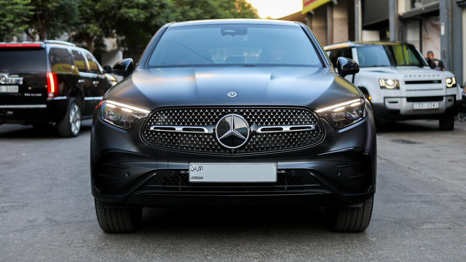 Front view of a sleek Mercedes-Benz SUV in a city setting, showcasing luxury in Amman, Jordan.