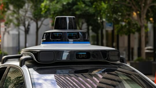 Detailed view of sensors atop an autonomous car, showcasing advanced technology in an urban setting.