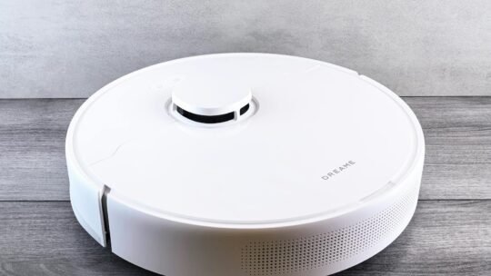 Sleek white robot vacuum cleaner on a wooden floor, perfect for smart home setups.