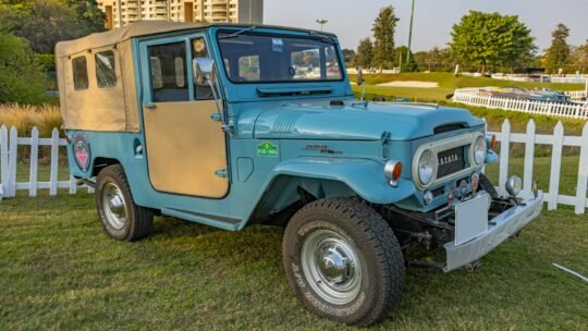 Classic Toyota Land Cruiser displayed outdoors at a Gurugram golf course event.