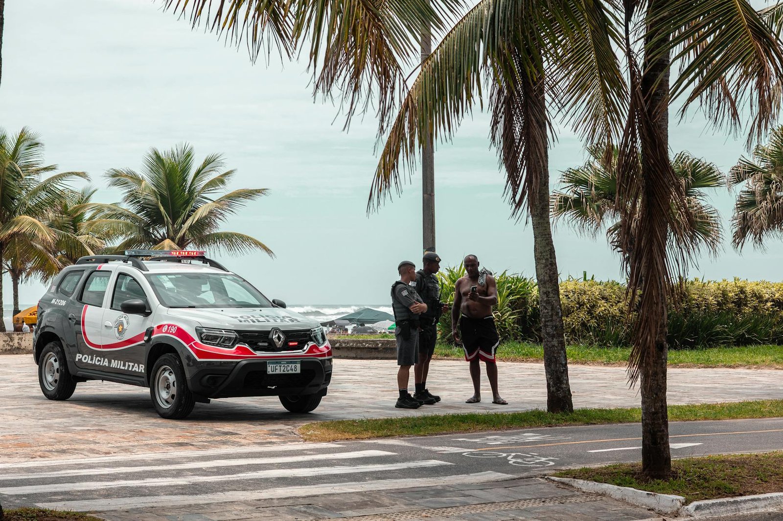 Police officers on duty near the beach with palm trees in Brazil.