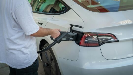 Electric car being charged at a station, highlighting eco-friendly transportation.