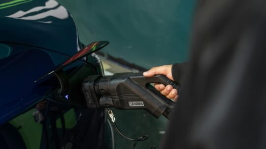 Close-up of an electric vehicle being charged at a station.