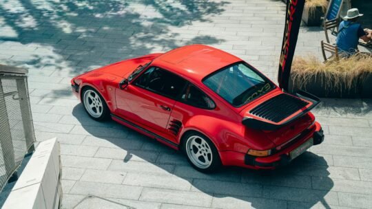 A vintage red sports car parked outdoors in Southampton, UK under bright sunlight.