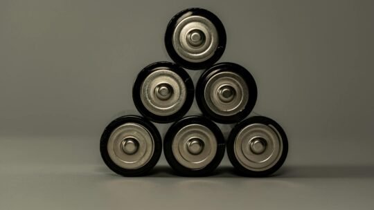 Metallic AA batteries stacked in a pyramid shape, symbolizing power and energy storage.