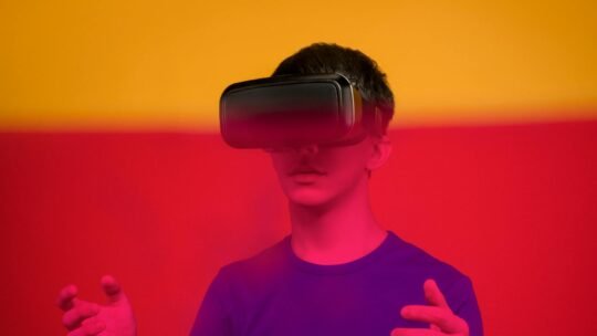 Young man exploring virtual reality with VR headset amid vibrant colors.