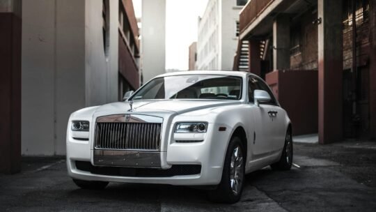 Elegant white luxury car parked in an urban alley, exuding sophistication and style.