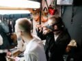 Diverse performers prepare with makeup and costumes in a vibrant dressing room.