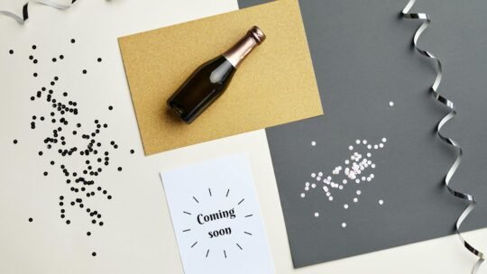 Flat lay image of a champagne bottle and festive decorations, perfect for celebratory themes.