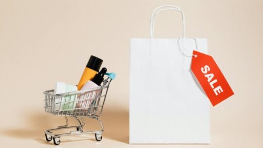 Minimalist image featuring a shopping cart with products and a sale-tagged bag.