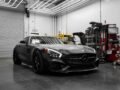 Matte black Mercedes-Benz AMG GT S parked in a stylish garage.