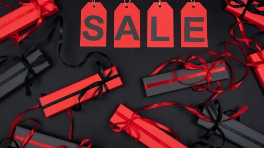 Red and black gift boxes with SALE tags on a black background, perfect for promotions.