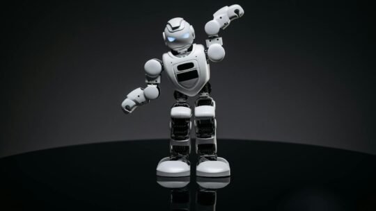 A white robot toy stands confidently in a studio setting, showcasing advanced design.